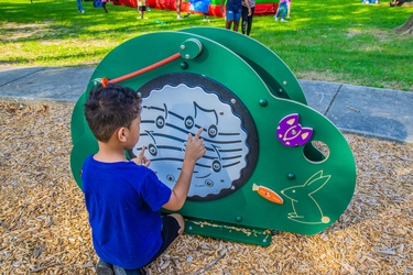 young boy playing on the music maker on the playground